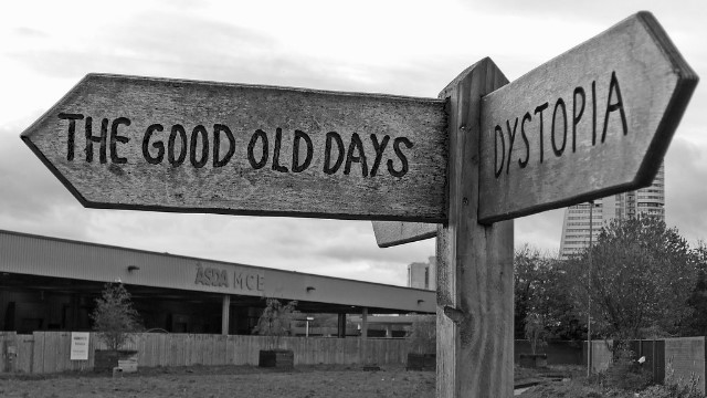 A sign that has to parts, one says "Good Old Days" the other says "Dystopia"