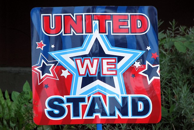 A sign that reads "United We Stand" in red, white and blue, with a star in the middle