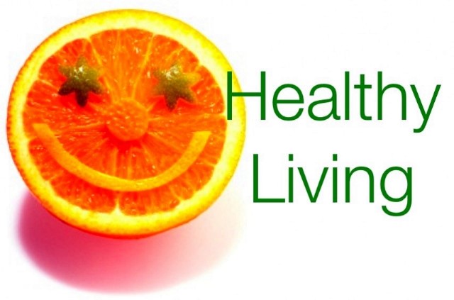 A picture of an orange with a smiley face on it and the text "Healthy Living"